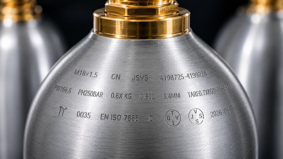 A close-up of the markings on a CO2 cylinder shoulder, showing compliance stamps.